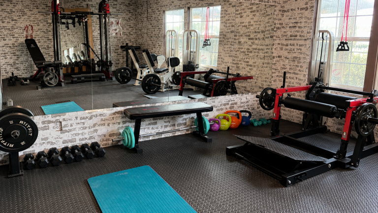 Home gym equipment setup with dumbbells, weight bench, Smith machine and hip thrust machine